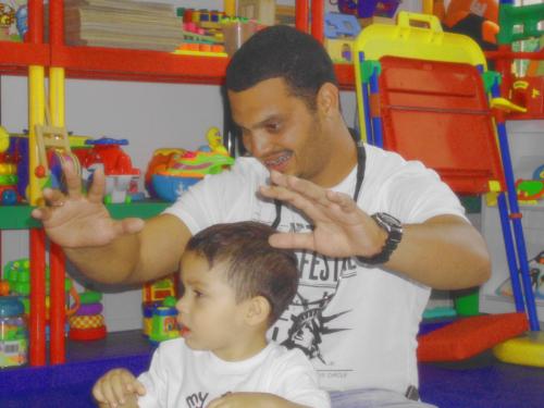 Niño con papá ejercitando manos-oidos